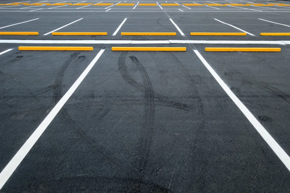 Empty asphalt parking lot with white lines.